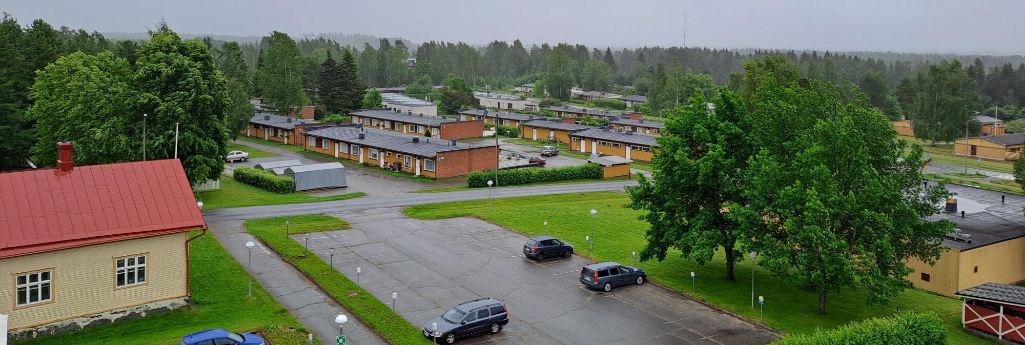 Asunto Oy Kinnulanrinteetn rivitalon kunnantalon katolta kuvattuna. Etualalla kunnantalon pysäköntialue ja vasemmalla Vanha Kinnula (tarinatupa).