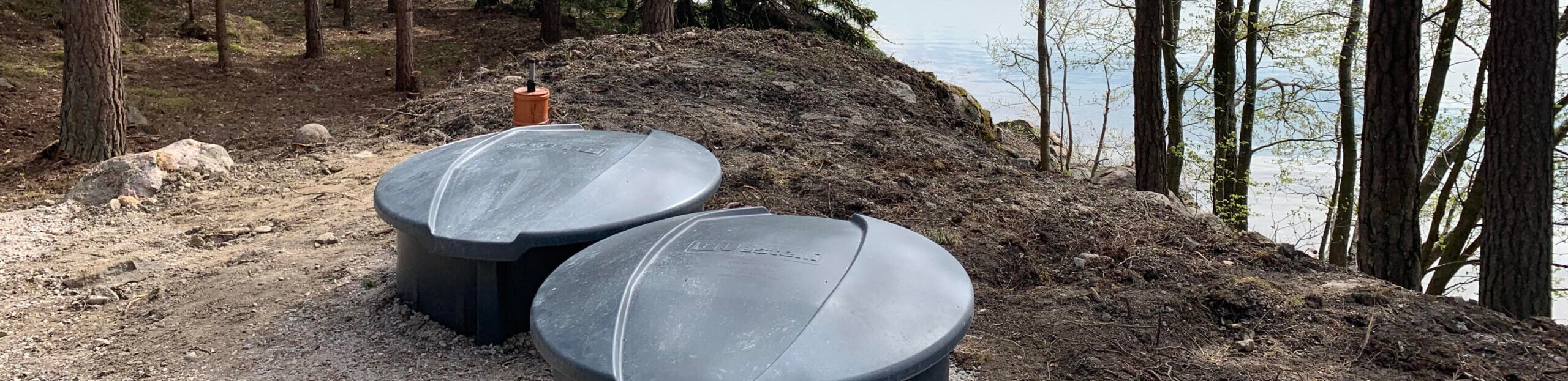 Jätevesisäiliöt valmiiksi asennettuna vesistön rannalle